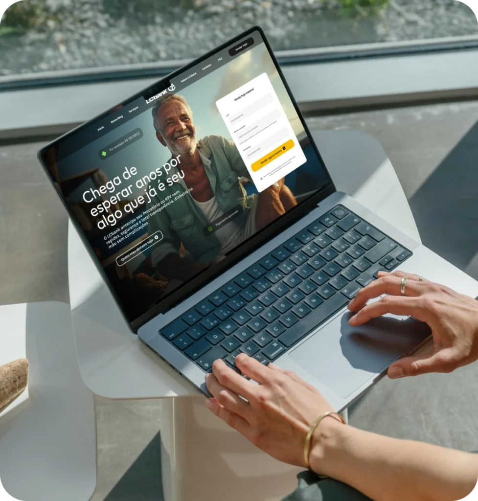 Laptop exibindo site do LBank com homem sorrindo e formulário de login.