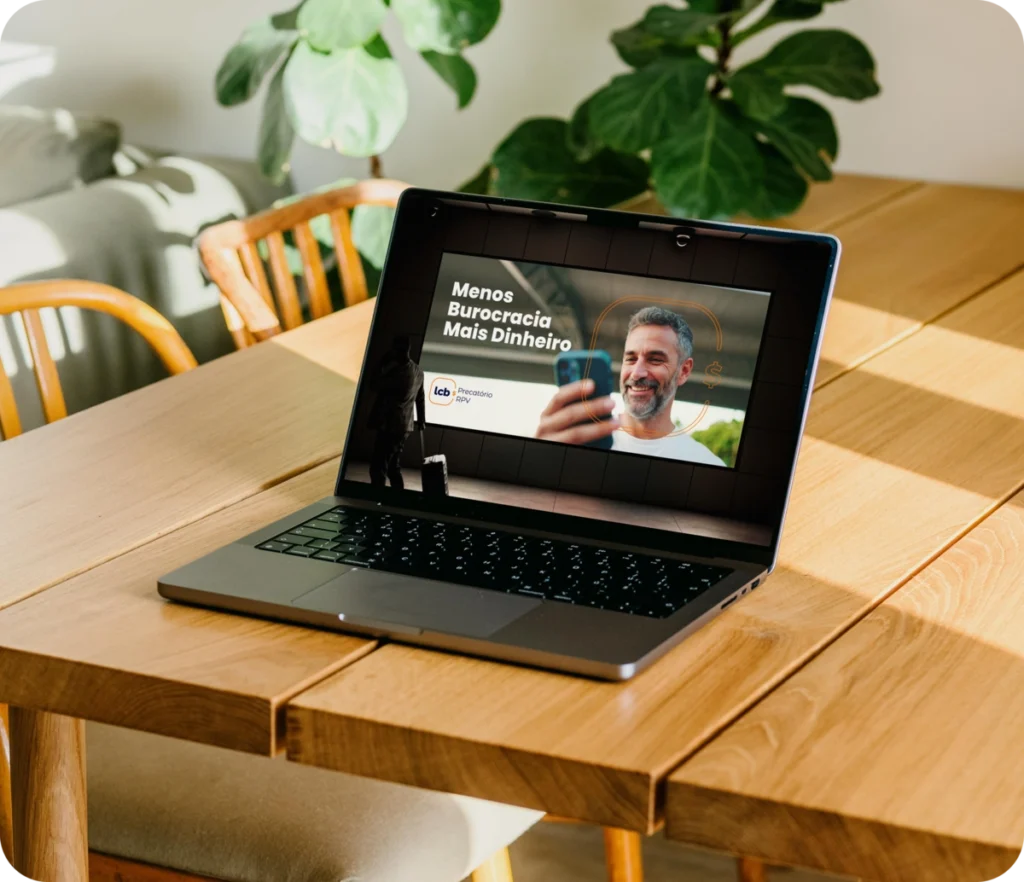 Tela de laptop exibe "Menos Burocracia Mais Dinheiro" com homem sorrindo
